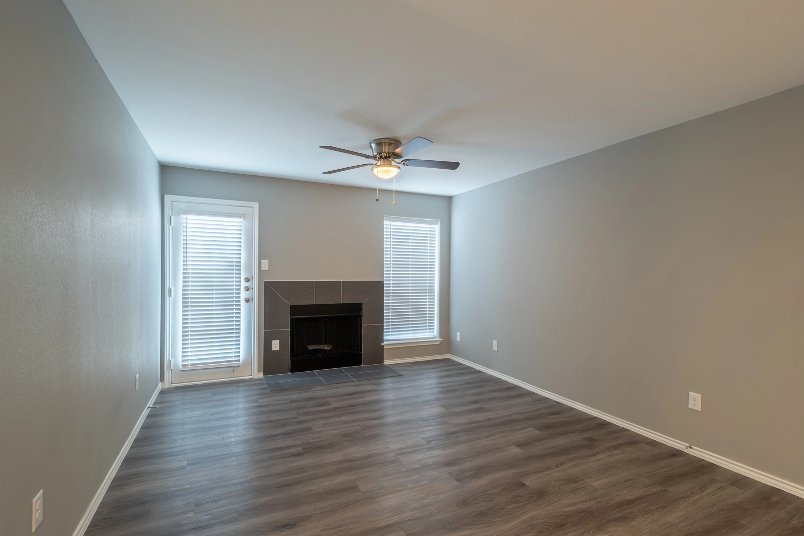 Living room with wood-burning fireplace at Crossings at Irving in Irving, Texas