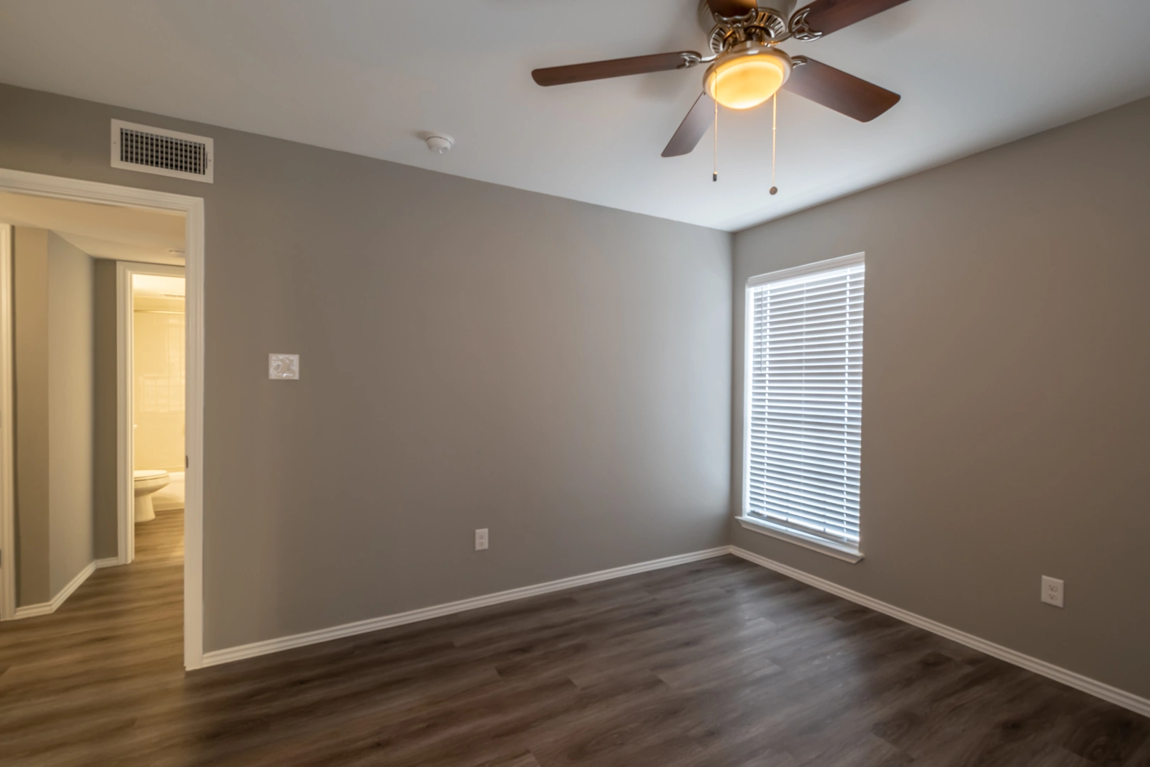 Primary bedroom with ensuite entry at Crossings at Irving in Irving, Texas