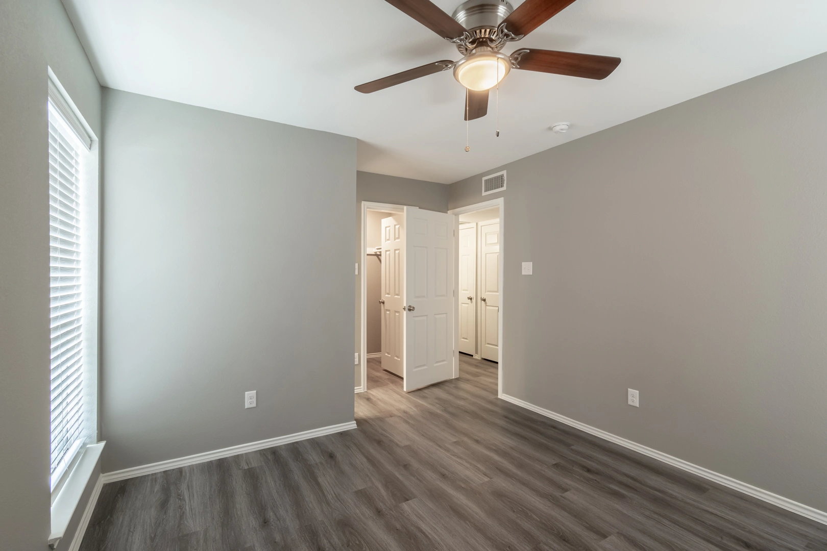 Primary bedroom with walk-in closet at Crossings at Irving in Irving, Texas