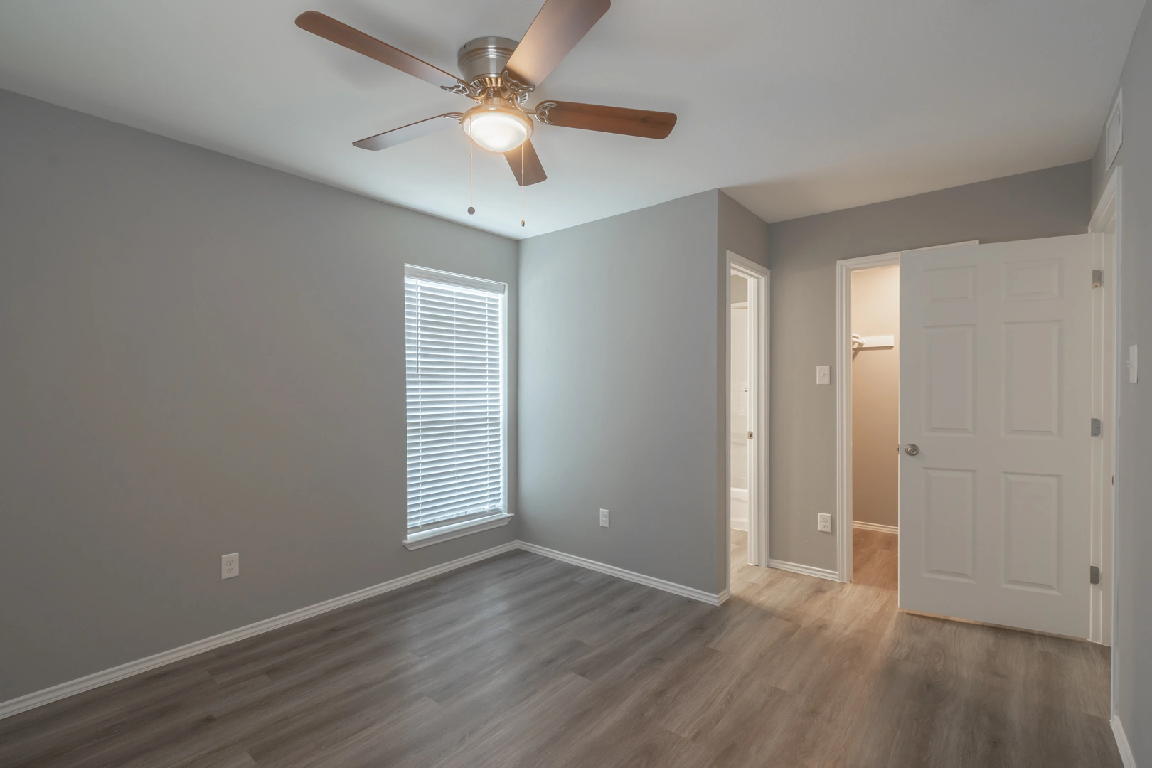 Bright bedroom with ceiling fan at Crossings at Irving in Irving, Texas